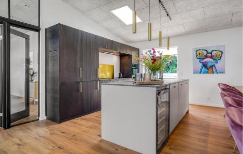 a kitchen with wooden cabinets and a counter with flowers on it at Beautiful Home In Børkop With Kitchen in Børkop
