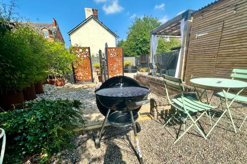 a grill in a garden with a table and chairs at Charles Alexander Short Stay - Derbe House in Lytham St Annes