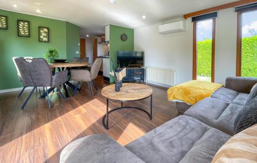 a living room with a couch and a table at Awesome Stacaravan In Tzummarum in Tzummarum