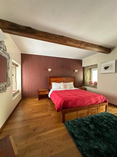a bedroom with a large bed with red sheets at Residência das Louras in Viana do Castelo