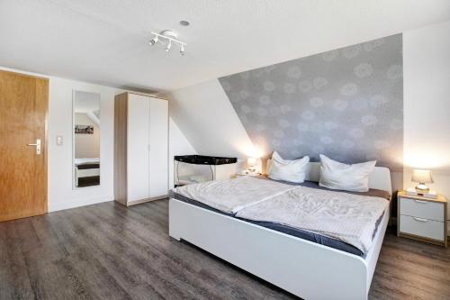 a bedroom with a white bed in a room at Ferienhaus Schleiluft in Kappeln