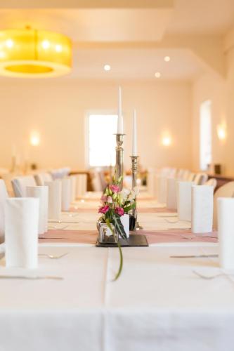 a long table with candles and flowers on it at Hotel Germania in Stadtallendorf