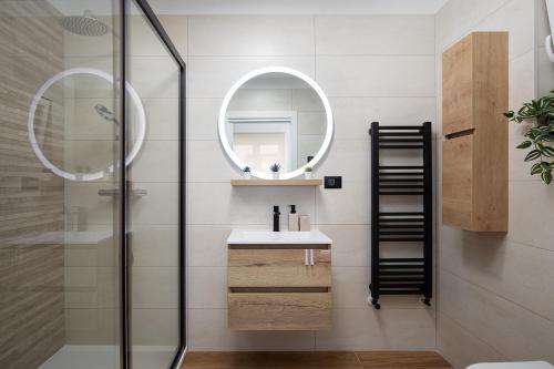 ein Badezimmer mit Dusche, Waschbecken und Spiegel in der Unterkunft Villa Blue Banjole in Banjole