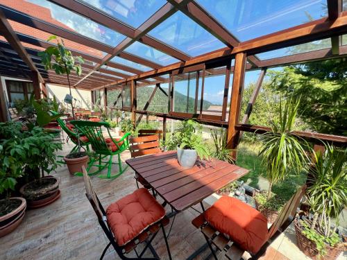 Un patio con una mesa y sillas de madera. en Art'e Boutique Rooms, en Băile Tuşnad