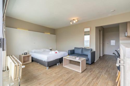 a hotel room with a bed and a couch at Value Stay Residence Mechelen in Mechelen