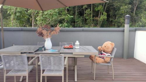 a teddy bear sitting on a chair next to a table at 莫干山云上别墅 in Houhong
