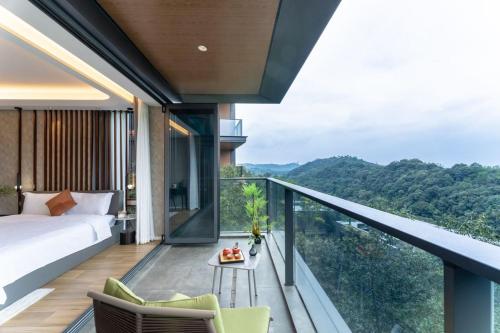 a bedroom with a balcony with a bed and a table at 莫干山云上别墅 in Houhong
