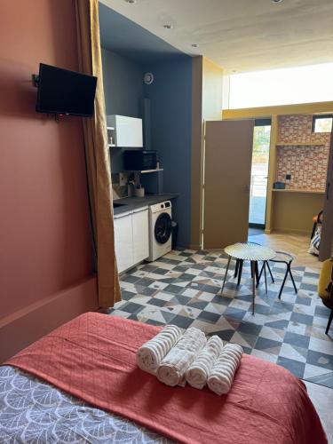 - une chambre avec un lit et des serviettes à l'étage dans l'établissement Appartement hyper centre, à Bordeaux