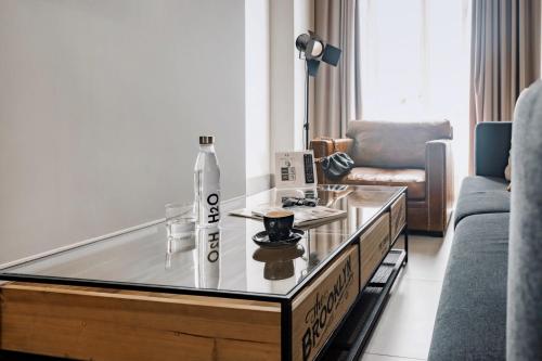 a living room with a glass coffee table with a bottle on it at HO Puerta de Purchena By Olivencia in Almería