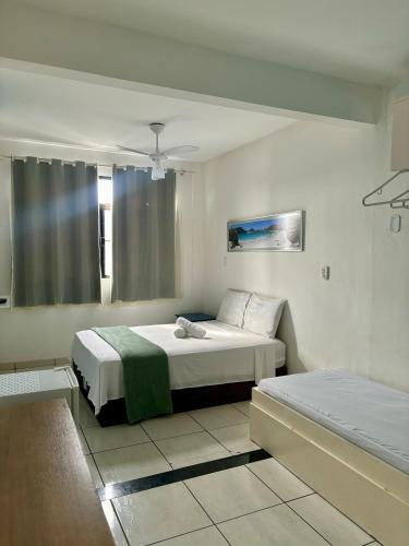 a bedroom with a bed and a window at Pousada Escotilha in Arraial do Cabo