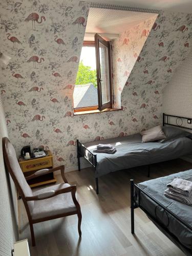 une chambre avec deux lits et une chaise et une fenêtre dans l'établissement Auberge de la chesnaie, à Pleudihen-sur-Rance