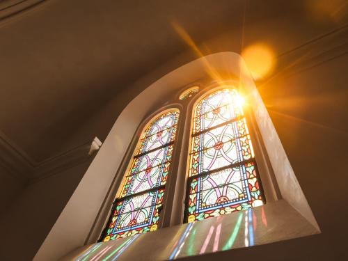 a sun shines through a stained glass window in a church at Château du Parc - Gîtes & spas à Pézenas in Pézenas