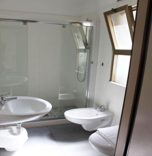a bathroom with a shower and a sink and a toilet at Luna Hotel Rimini in Rimini