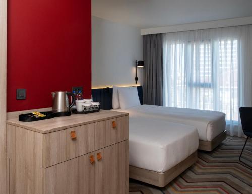 a hotel room with a bed and a red wall at Hampton By Hilton Istanbul Merter in Istanbul