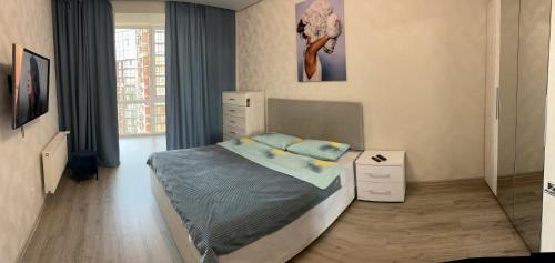 a bedroom with a bed and a large window at Апартаменти в ЖК Яровиця біля ТРЦ Промінь in Lutsk