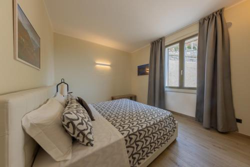a bedroom with a bed and a window at Argegno Como Lake in Argegno