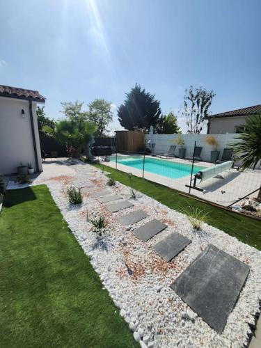 une cour avec une piscine et un jardin paysager dans l'établissement Chambre Armelle, chambre privée avec accés piscine, à Artigues-près-Bordeaux
