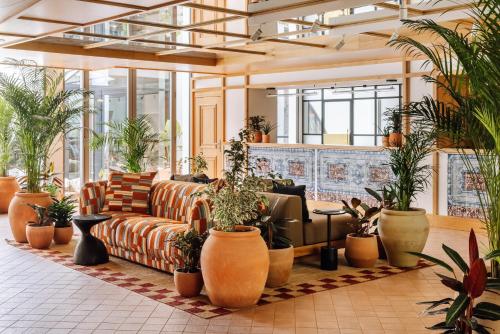 a lobby with a couch and a lot of plants at Locke de Santa Joana in Lisbon