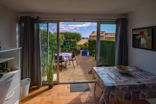 - un salon avec une porte s'ouvrant sur une terrasse dans l'établissement T2 en bord de mer à St Aygulf, à Fréjus