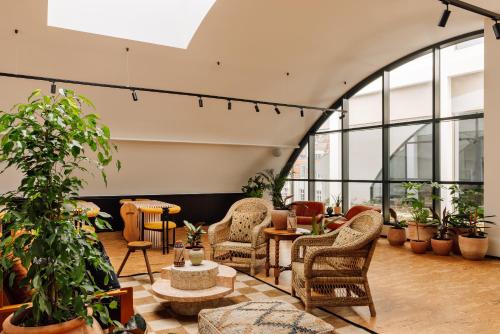a lobby with chairs and tables and plants at Locke de Santa Joana in Lisbon