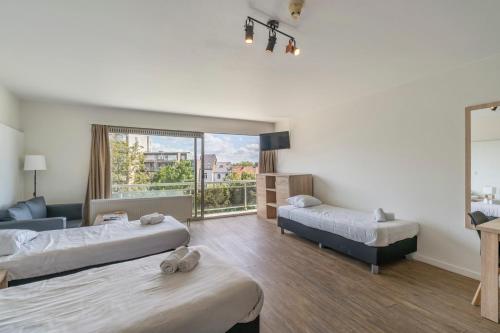a hotel room with two beds and a window at Value Stay Residence Mechelen in Mechelen