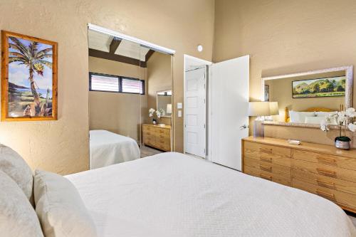 a bedroom with two beds and a mirror at Papakea E404 in Kahana