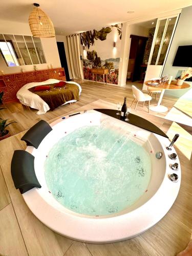 une grande baignoire au milieu d'un salon dans l'établissement Les Suites du Payré - Suite Romance, à Saint-Hilaire-de-Talmont