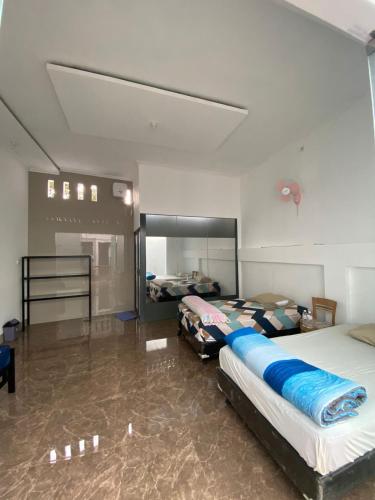 a bedroom with two beds in a room at Hotel Cigadung Holiday syariah in Bandung