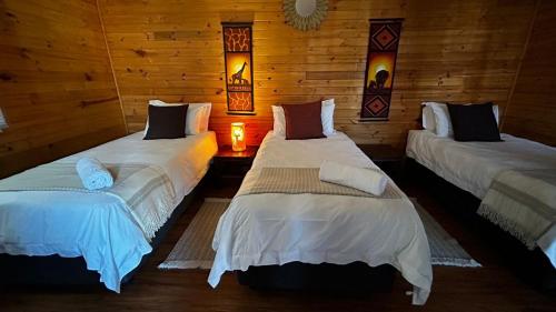 deux lits dans une chambre aux murs en bois dans l'établissement 9 Serendipity Stay, à George