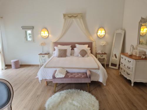 une chambre avec un grand lit à baldaquin dans l'établissement l'oasis girondine 4 étoiles, à Izon