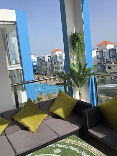 a couch on a balcony with a view of a pool at appartement de luxe a cabonegro in Tetouan