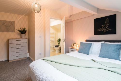 ダービーにあるcheerful double en-suite room with free wifiの大きな白いベッドと青い枕のある寝室