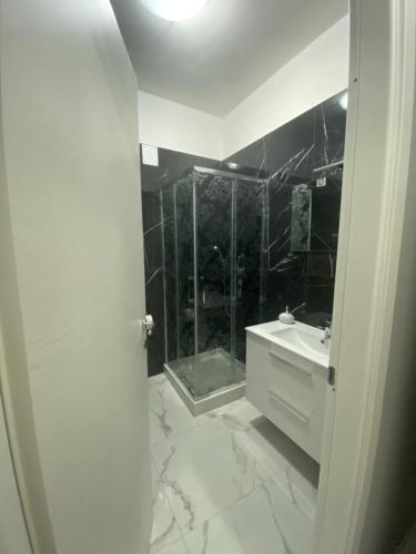 a white bathroom with a shower and a sink at Al centro in Reggio Calabria