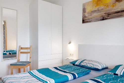 a bedroom with two beds and a chair at Santners Holiday in Fie allo Sciliar