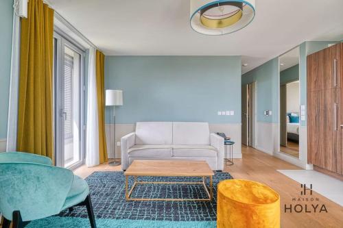 un salon avec un canapé blanc et une table dans l'établissement Le Merveilleux - À Auteuil - 360B, à Paris