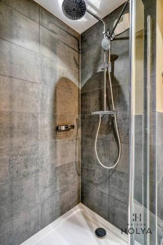 une douche avec une porte vitrée dans une salle de bain dans l'établissement Le Merveilleux - À Auteuil - 360B, à Paris