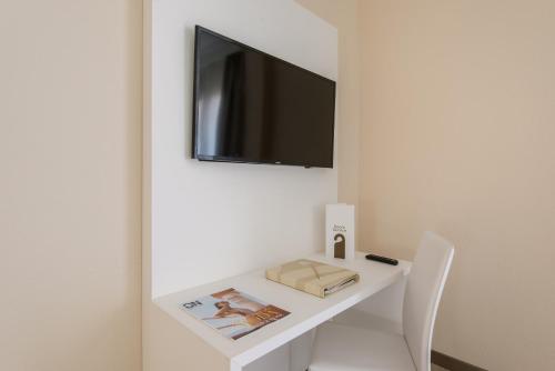 a white desk with a television on a wall at Oliva Nova Beach & Golf Hotel in Oliva