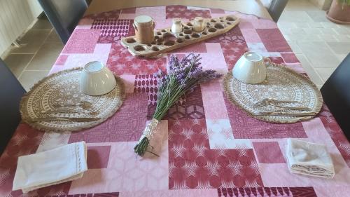 une table avec un tissu de table rose, des assiettes et des bougies dans l'établissement Kanahau, à Cambayrac