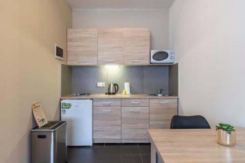 a small kitchen with a white refrigerator and wooden cabinets at Value Stay Residence Mechelen in Mechelen
