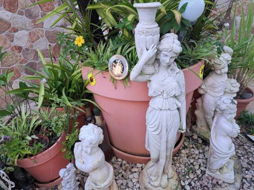 a statue of a woman standing next to a pot of plants at KANALU Land in Bouillante