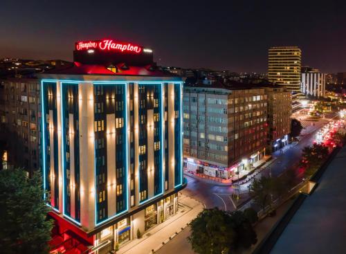a building with a neon sign on top of it at night at Hampton By Hilton Istanbul Merter in Istanbul