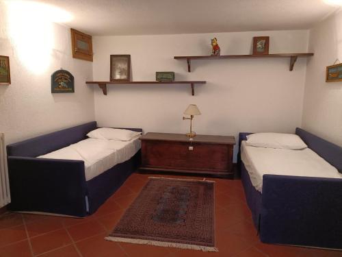 Habitación con 2 camas, mesa y estanterías en The saxe relax in the mountain, en Courmayeur