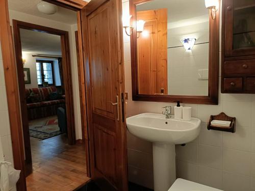 un baño con lavabo y espejo en The saxe relax in the mountain, en Courmayeur