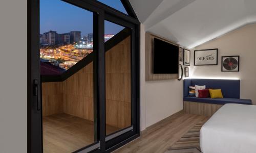 a room with a balcony with a view of the city at Hampton By Hilton Istanbul Merter in Istanbul