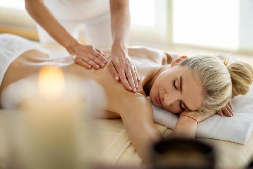 a woman getting a massage from a massage therapist at Vitalhotel der Parktherme - inkl Thermeneintritt & Sauna in Bad Radkersburg