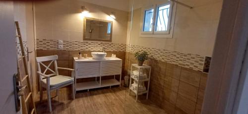 une salle de bain avec un lavabo, un miroir et une chaise dans l'établissement Chez Giotto, à Saint-Rémy-de-Provence