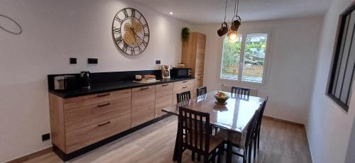 une cuisine avec une table et une horloge au mur dans l'établissement Chez Giotto, à Saint-Rémy-de-Provence
