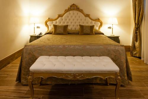 a large bed with a white bench in a bedroom at Hotel Al Ponte Mocenigo in Venice