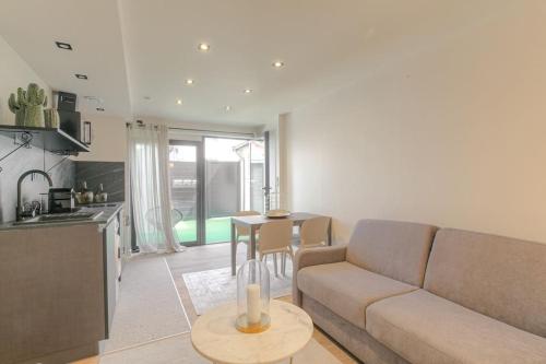 un salon avec un canapé et une table dans l'établissement Appartement chaleureux pour 4, Villeurbanne-Cusset, à Villeurbanne