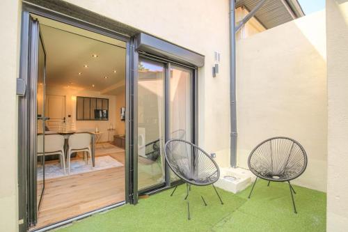 2 chaises assises sur un balcon avec salle à manger dans l'établissement Appartement chaleureux pour 4, Villeurbanne-Cusset, à Villeurbanne